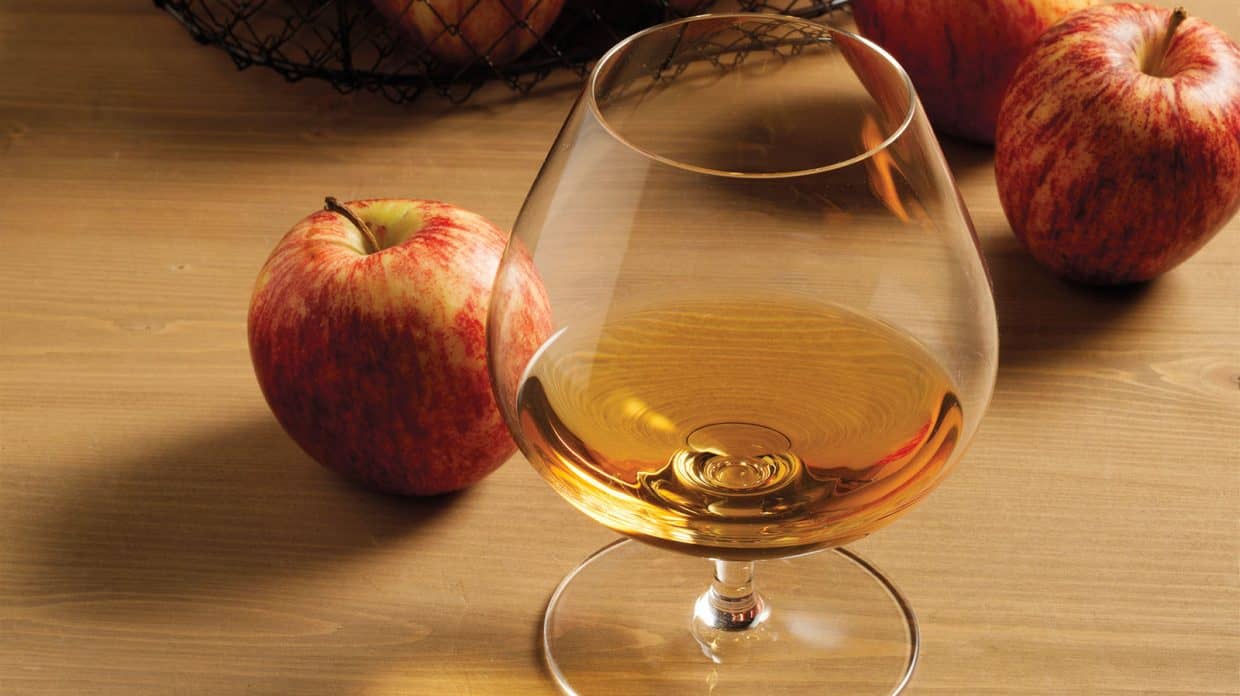 Vaso de degustación de whisky cerca a una manzana